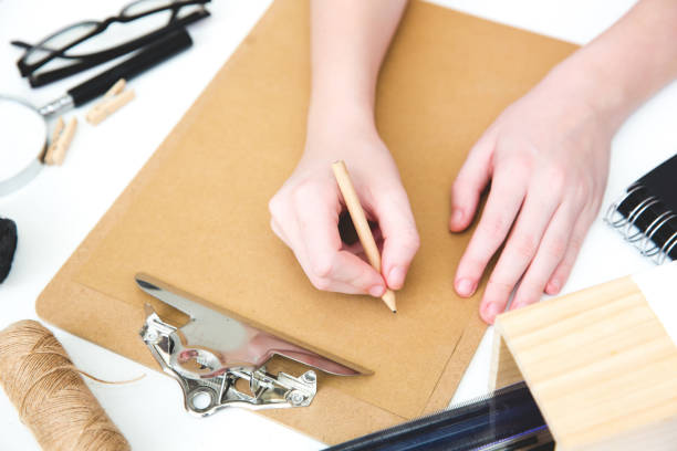 istock Hands writing over clipboard on  white background, template, mock up, flat lay, top view 687758876
