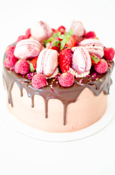 istock Birthday chocolate cake with strawberries, raspberries and macarons. 687762800