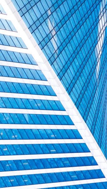 istock Abstract skyscrapers with reflection in windows blue sky, white clouds and sun glare 687764168