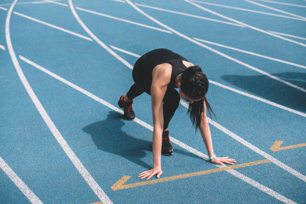 istock Concentrated young sportswoman in starting position on running track stadium 687764310