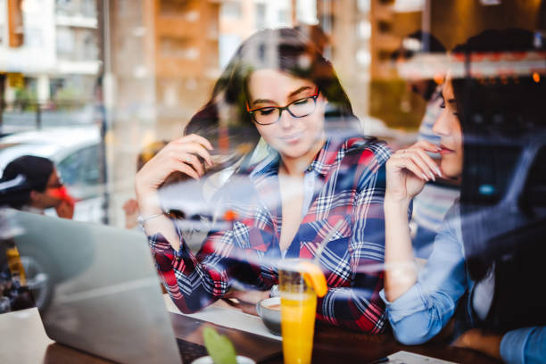 istock Girls working on a laptop behind cafe window 687770518