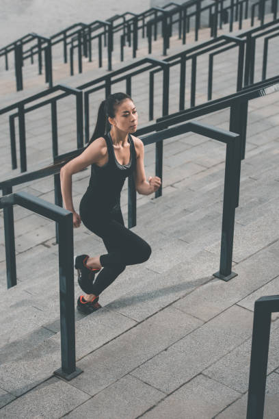 młoda kobieta fitness w odzieży sportowej działa na stadionie schody - stadium empty seat women zdjęcia i obrazy z banku zdjęć