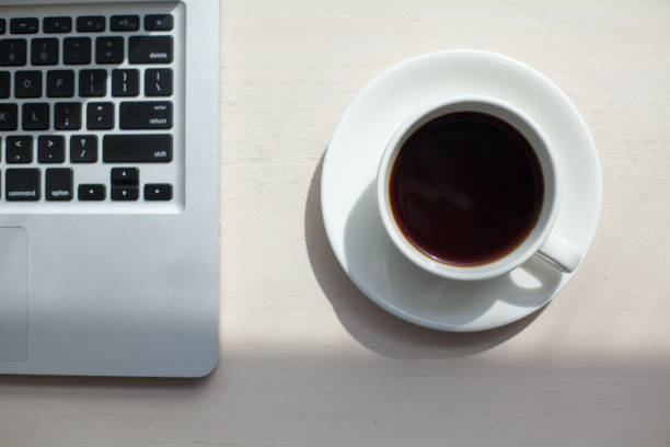 istock Coffee and laptop on wooden table 687784068