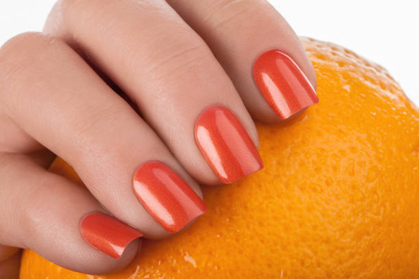 Orange nail polish. Orange nails on a white background with fruit. yellow nail polish stock pictures, royalty-free photos & images