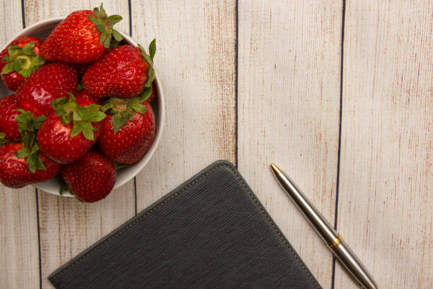 Strawberry, tablet and pen summer wooden background