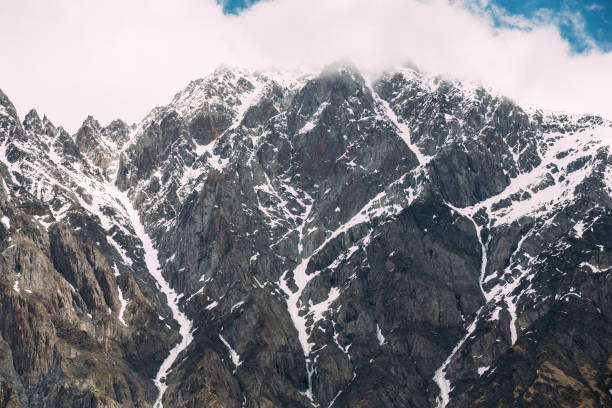 istock Clouds fly low over rocks. Mountain peaks covered with snow. Varied mountain landscape in Mtskheta-Mtianeti region, Georgia. 687790226