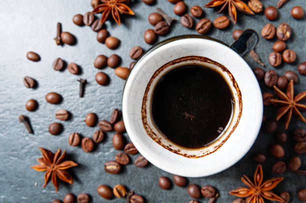 istock Coffee cup with coffee beans on stone table background with star anise. 687790560