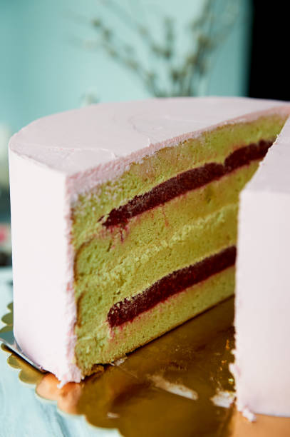 Cut a pink cake in a minimalist style without ornaments. Filling with jam