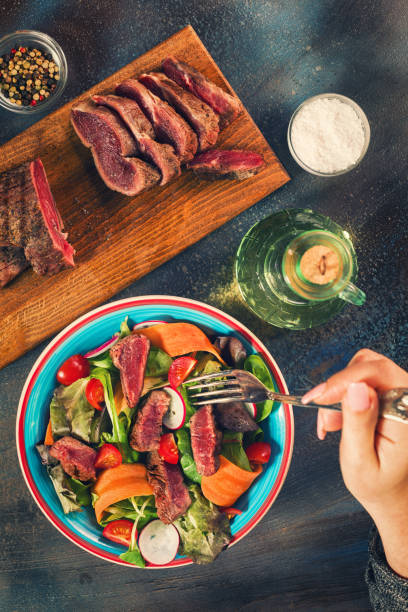 istock Young Women Eating Spicy Beef Steak Salad 687797630