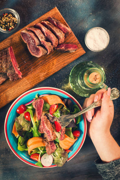istock Young Women Eating Spicy Beef Steak Salad 687797666