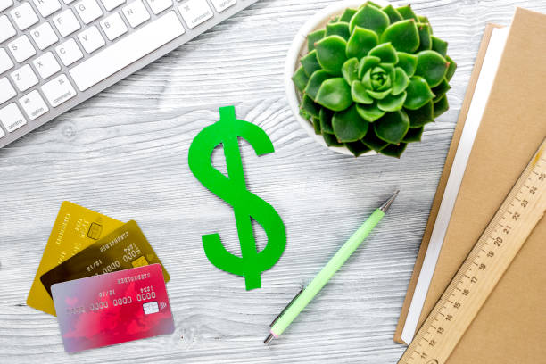 istock fee-paying education set with dollar sign, books and cards on light table background top view 687797744