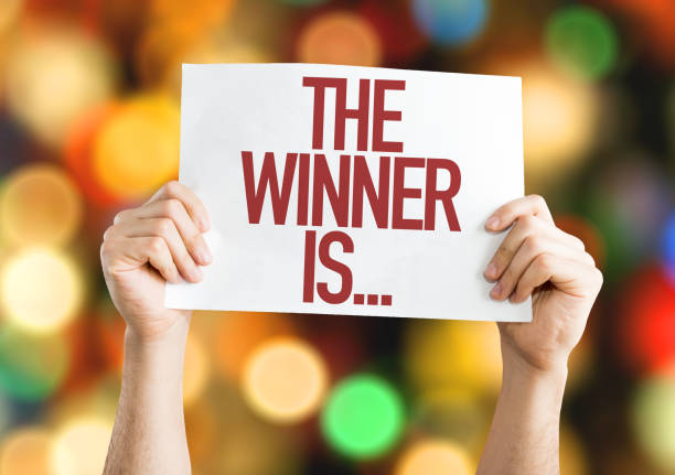 The Winner Is... placard The Winner Is... placard with bokeh background announcement message photos stock pictures, royalty-free photos & images