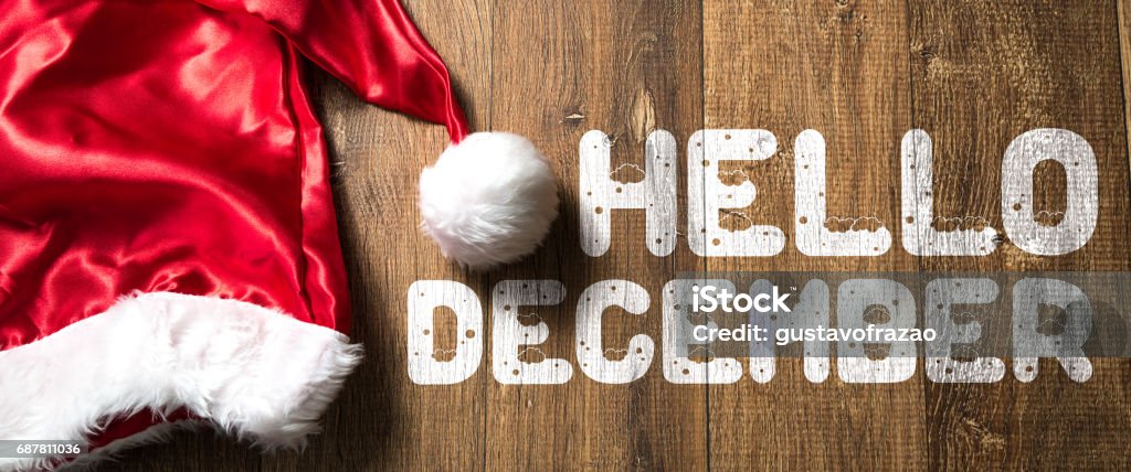 Hello December sign Hello December written on wooden background with Santa Hat December Stock Photo