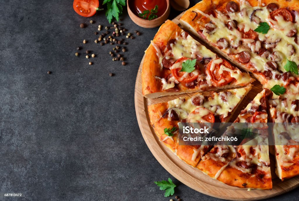 Home pizza with salami, tomato and cheese on a black background Pizza Stock Photo