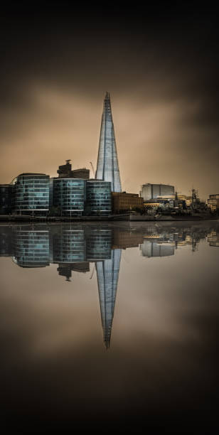Facade of skyscraper made with mirrors from downside and clouds reflecting in Intesa Sanpaolo tower of Turin
