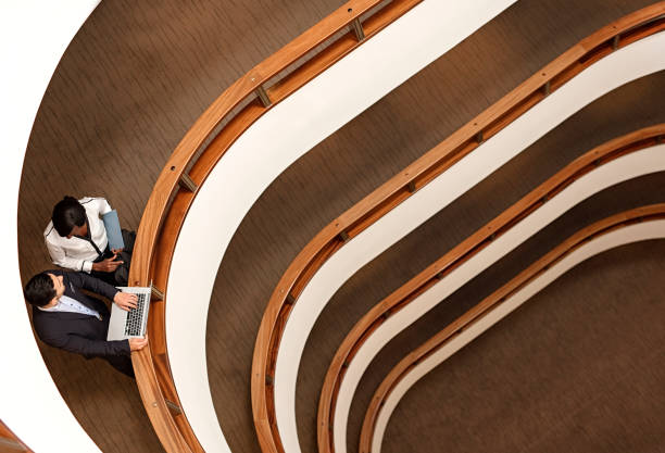 istock Two Business People Standing in the office building  and Using Laptop 687820524