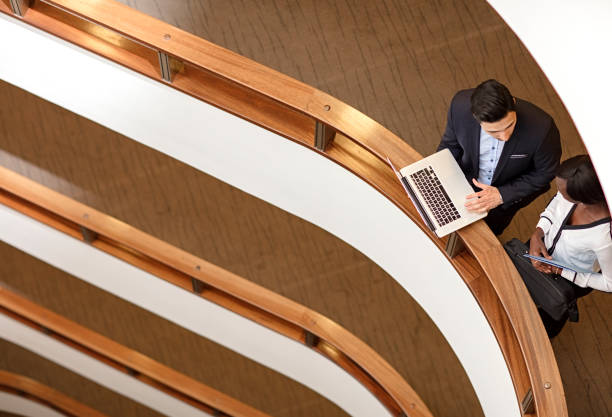 istock Two Business People Standing in the office building  and Using Laptop 687824702