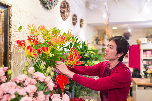 Japanese male florist working in flower shop