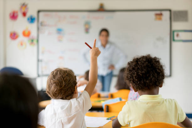 istock Boy raising his hand in class at the school 687830464