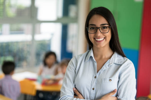 retrato de un feliz profesor de américa latina en la escuela - preschool teacher fotografías e imágenes de stock