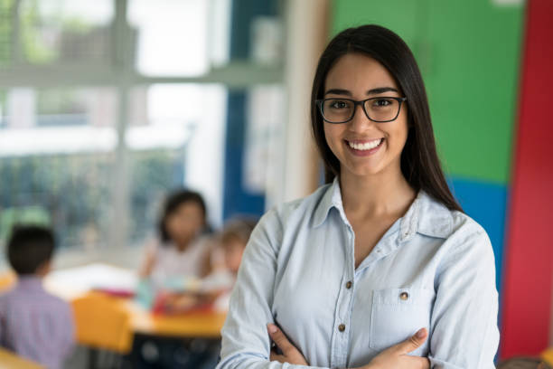 学校で幸せなラテン アメリカ教師の肖像 - 幼稚園教師 ストックフォトと画像