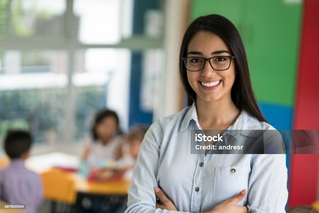 Portrait of a happy Latin American teacher at the school Portrait of a happy Latin American teacher at the school looking at the camera smiling - education concepts Teacher Stock Photo