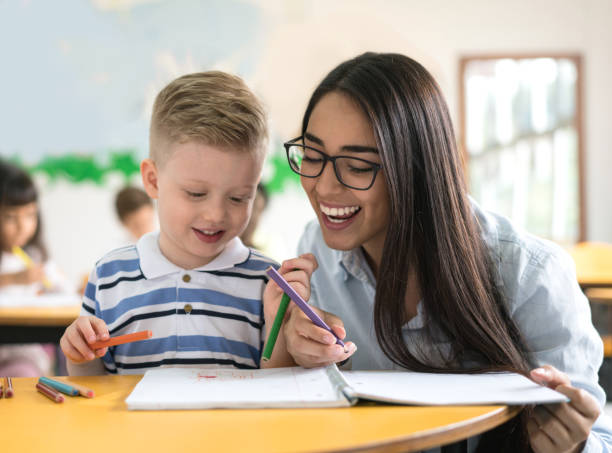 istock Happy teacher checking on a young student at the school 687830698