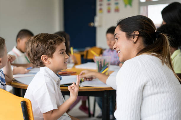 istock Happy boy talking to his teacher at the school 687830740
