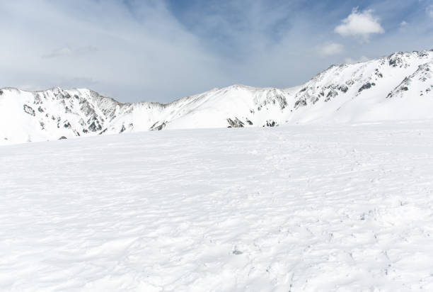 istock Rocks on the snow covered mountain under blue sky 687833314