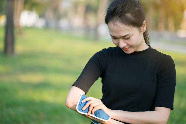 kobieta wprowadzenie okład z lodu na jej ból ramienia - ice women ice pack physical injury zdjęcia i obrazy z banku zdjęć