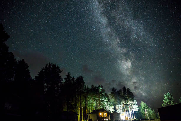 istock Night starry sky scene with illuminated cottage 687841020