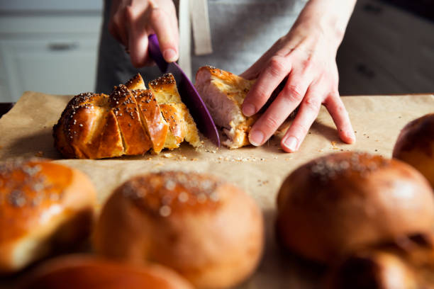 female hands slicing fresh bread - challah imagens e fotografias de stock