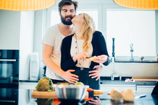 istock Beautiful couple having good time while cooking in the kitchen 687850488