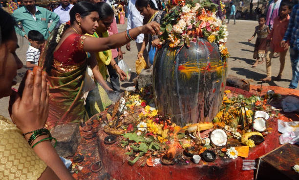 Hindus perform Puja to lord Shiva stone statue, near the temple, in Mahasihvaratri fesival stock photo