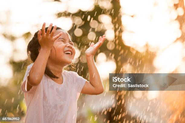 Happy Asian Little Girl Having Fun To Play With The Rain Stock Photo - Download Image Now