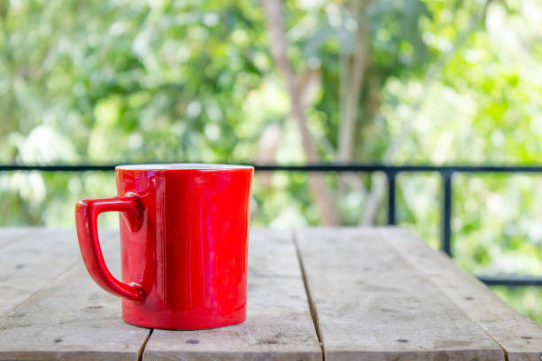 istock coffee cup on wood table with nature bokeh background 687864010