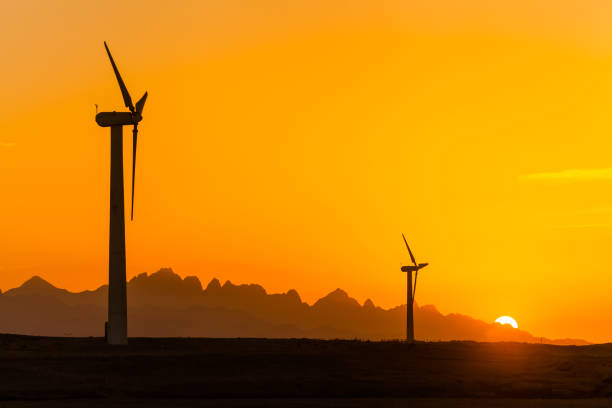 Big wind turbines in the desert against mountains