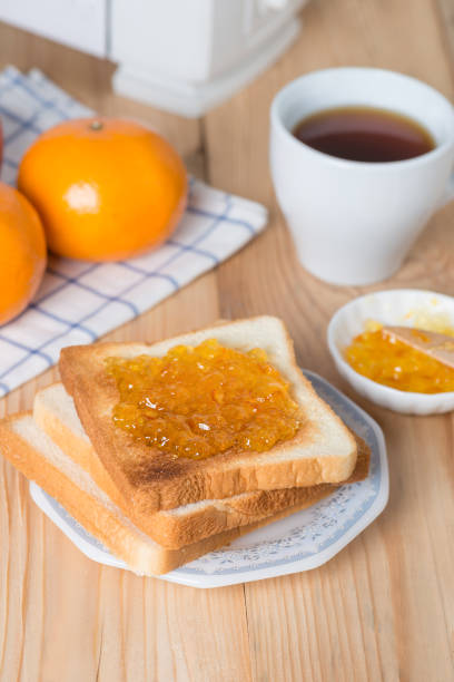 istock Slice of bread with orange jam and cup coffee. 687881200