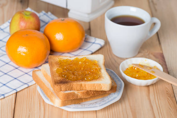 istock Slice of bread with orange jam and cup coffee. 687881206