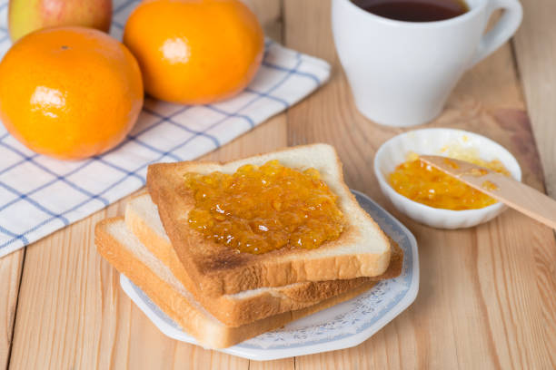 istock Slice of bread with orange jam and cup coffee. 687881208