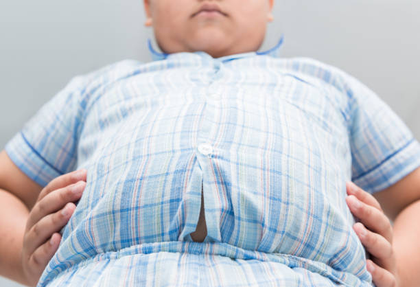 obese fat boy overweight. tight shirt of pajamas - belly button imagens e fotografias de stock