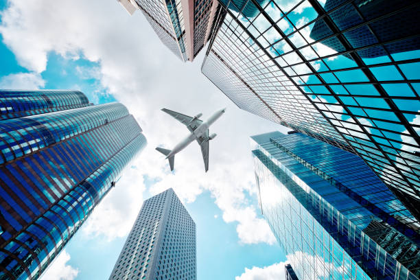 avion survolant des gratte-ciels commerciaux - flying over photos et images de collection