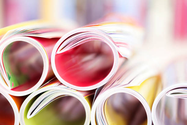istock Close up edge of colorful magazine stacking roll with  blurry bookshelf background for bublication and publishing concept , extremely DOF 687905462
