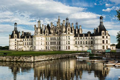 Chambord Chateau with reflection in the canal. Panoramic view, France. Loire Valley. Some turists in the image.