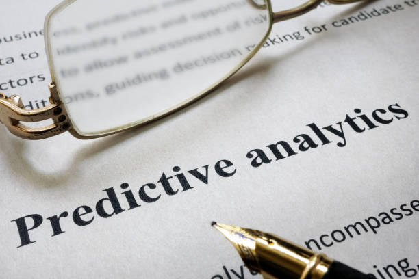 istock Page of paper with words Predictive Analytics and glasses. 687909620