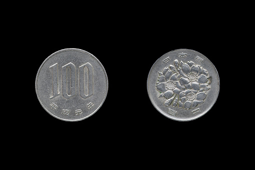 Japanese money, silver coin one hundred yen isolated on black background.