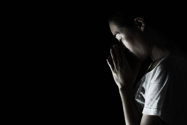 istock depress woman praying in the dark ( praying in secret room concept ) 687910008