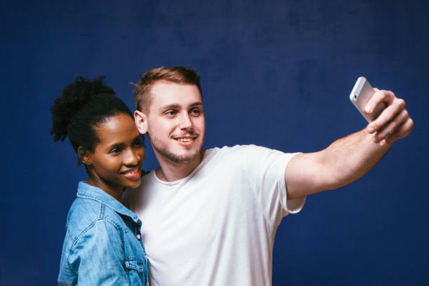 istock White man and black woman make selfie, fun and joy 687916438
