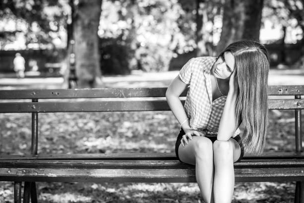 istock sad young woman sitting on a bench 687917524
