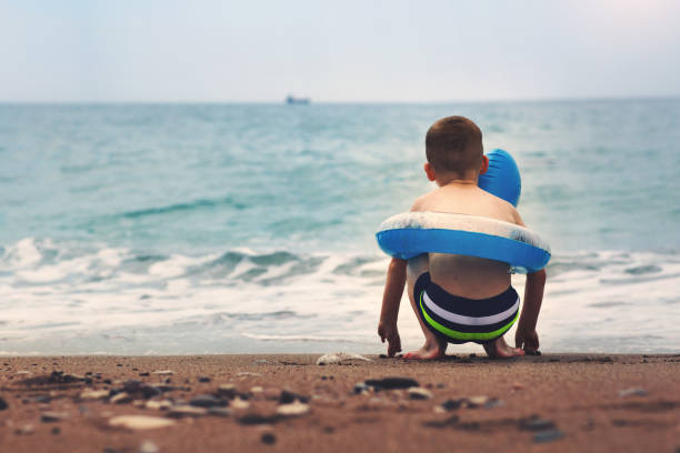 istock Cute little boy with colorful rubber ring on summer beach 687928308